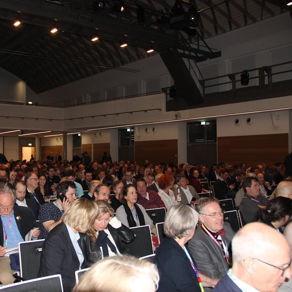 A large crowd of people sitting in a lecture hall.
